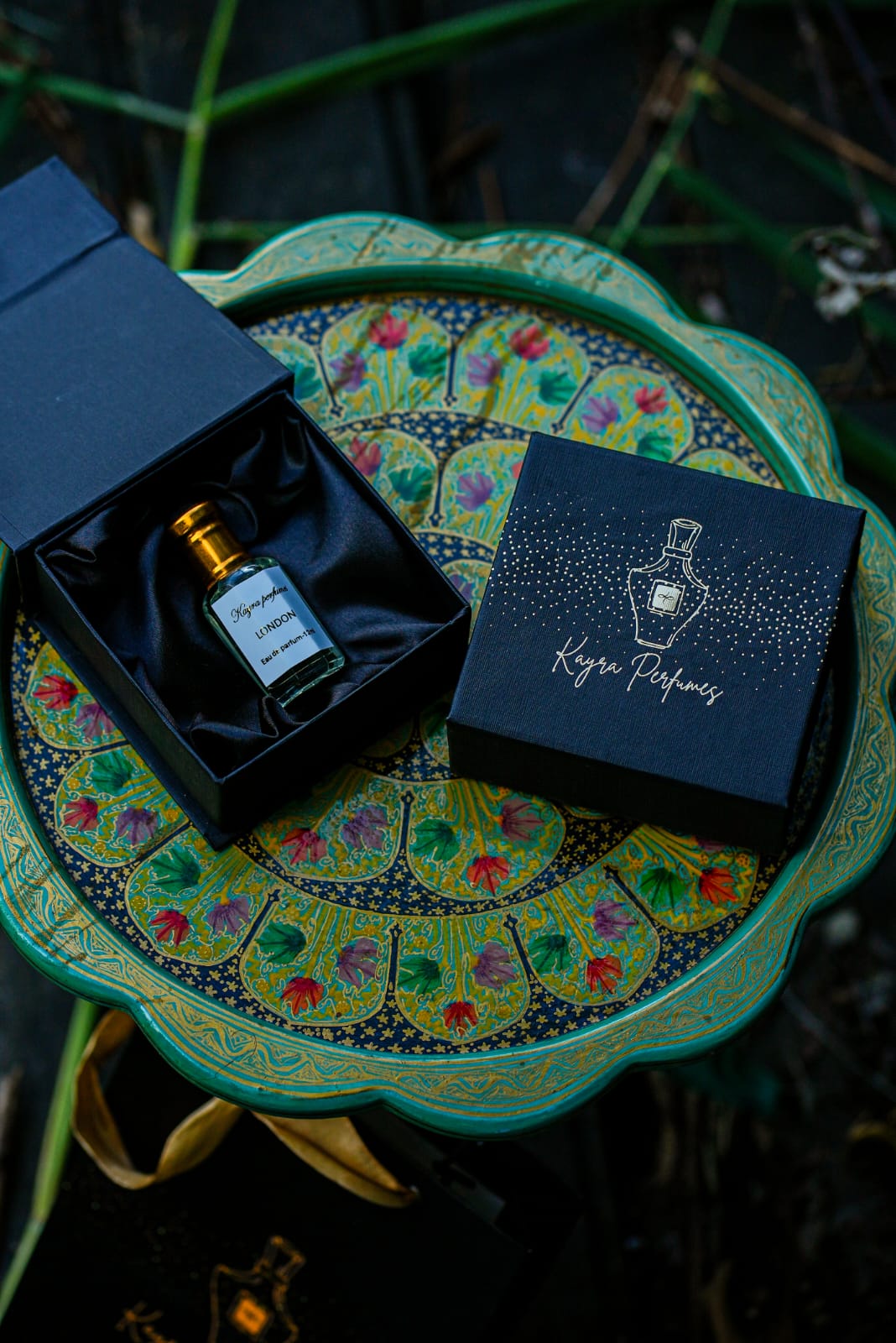 Kayra Perfumes London eau de parfum bottle in an open black box on a hand-painted Kashmiri tray